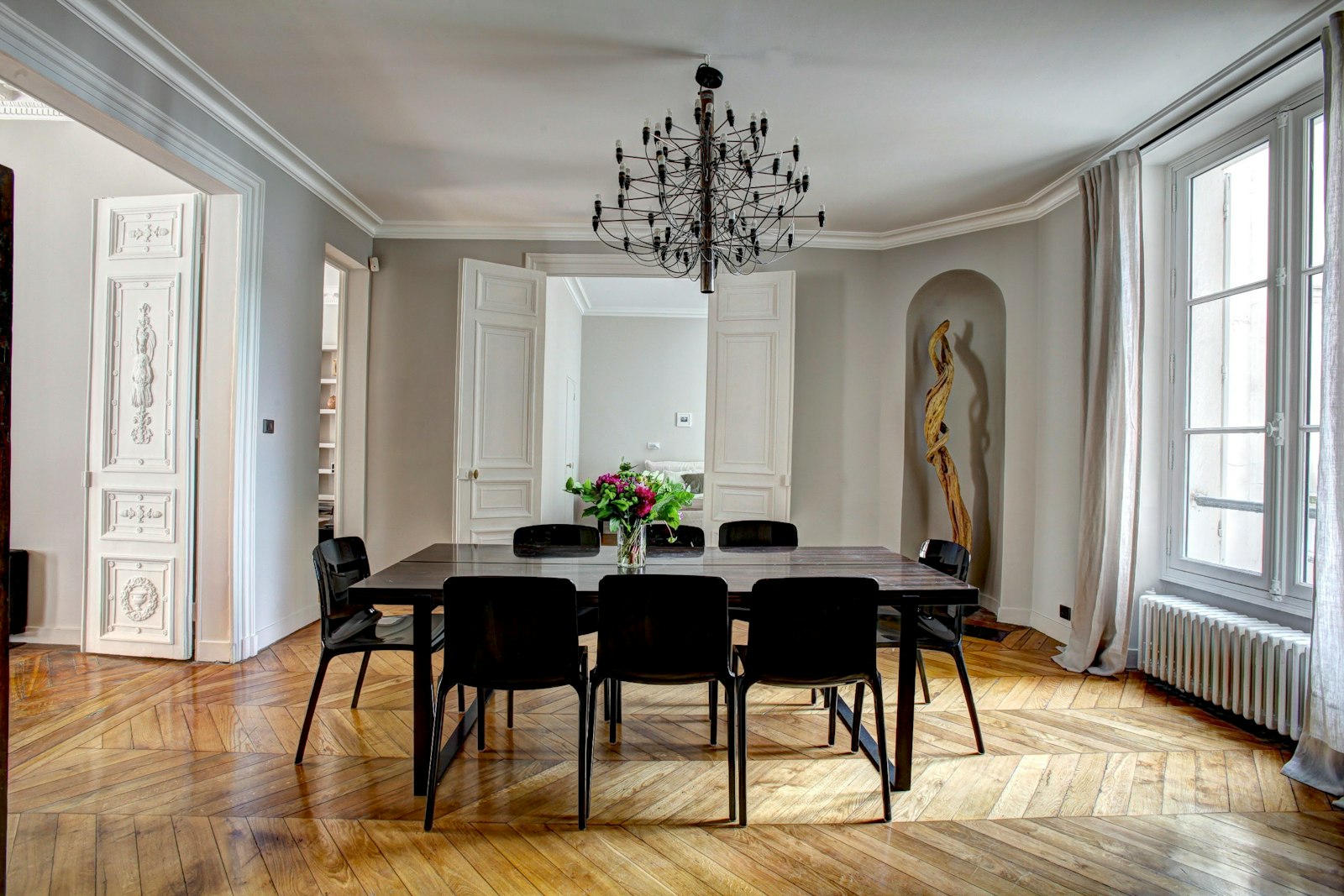 Salle à manger lumineuse d'un appartement parisien avec table en bois